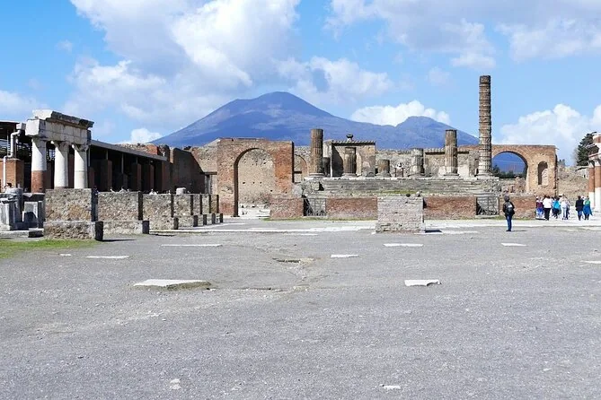 The open Forum of Pompeii with ruined colonnades and Vesuvius behind