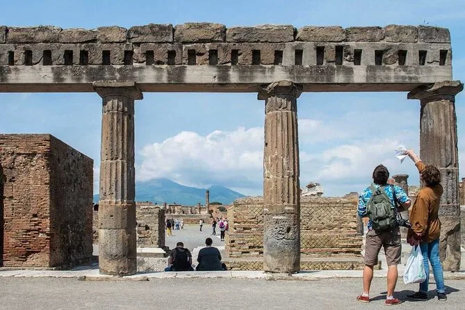 Visitors walking between the columns of the Forum in Pompeii